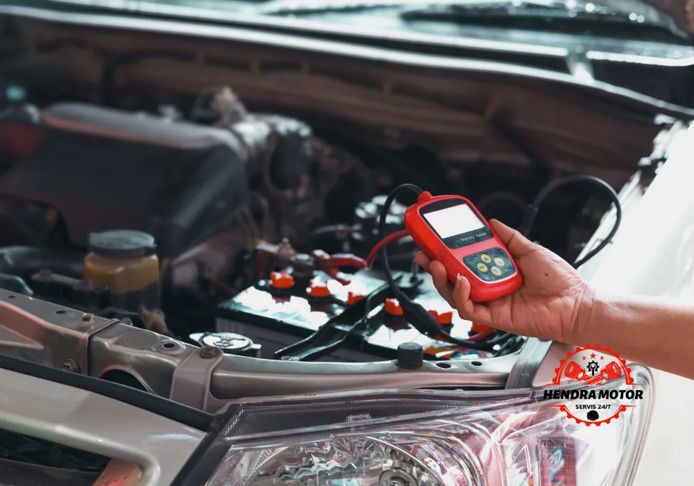 Bengkel mobil panggilan murah sedang melakukan jumper aki kendaraan.