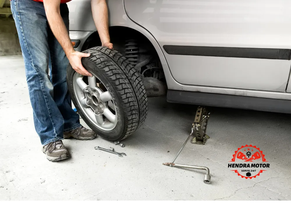 Jasa bengkel panggilan murah sedang mengganti ban kendaraan.