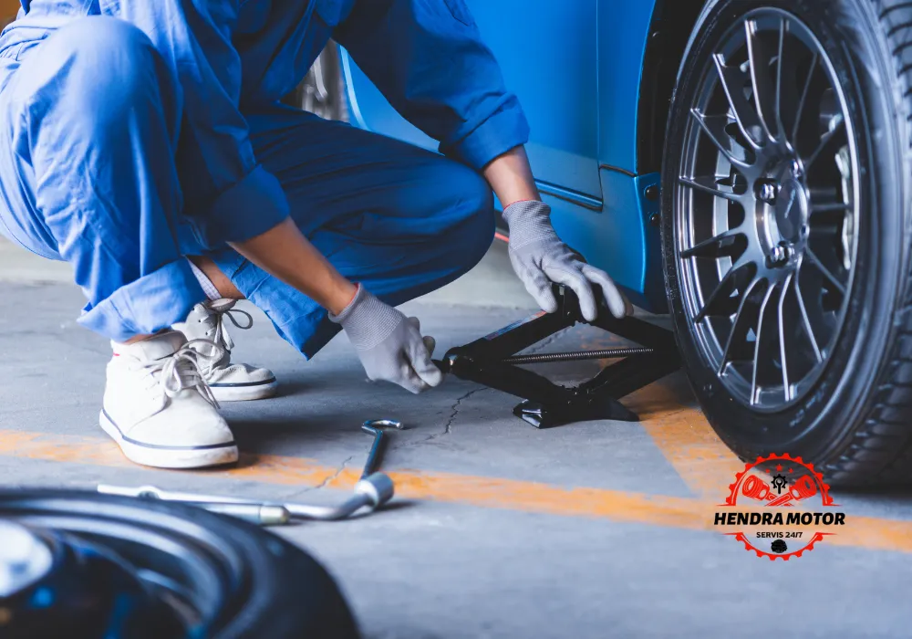 Mekanik panggilan sedang mengganti ban kendaraan.