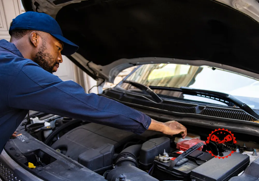 Montir bengkel panggilan sedang menangani mobil mogok.