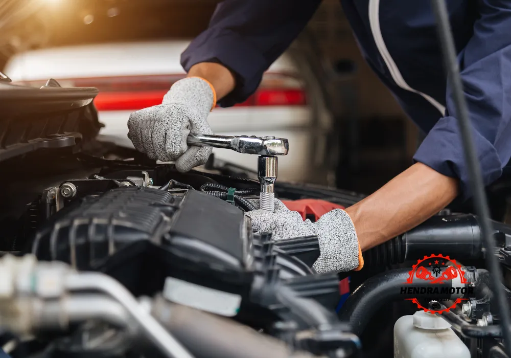 Teknisi bengkel panggilan melakukan tune up mobil.