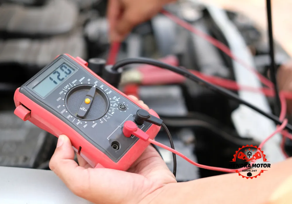 Teknisi bengkel panggilan melakukan perbaikan kelistrikan mobil.