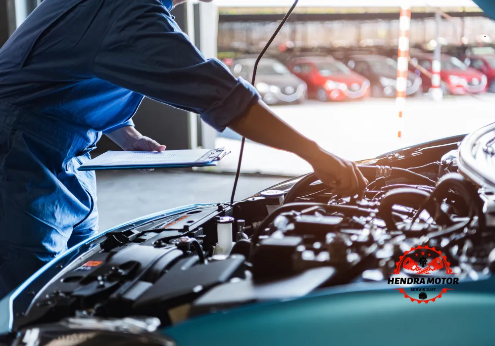 Montir mobil panggilan sedang menangani mobil mogok.