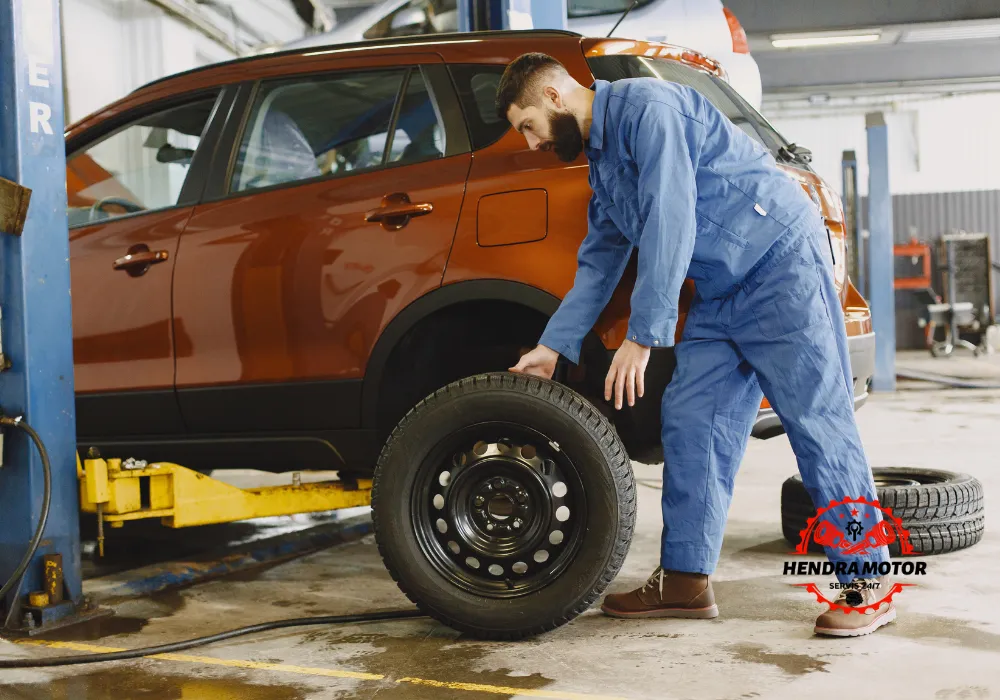 Montir panggilan sedang mengganti ban kendaraan.