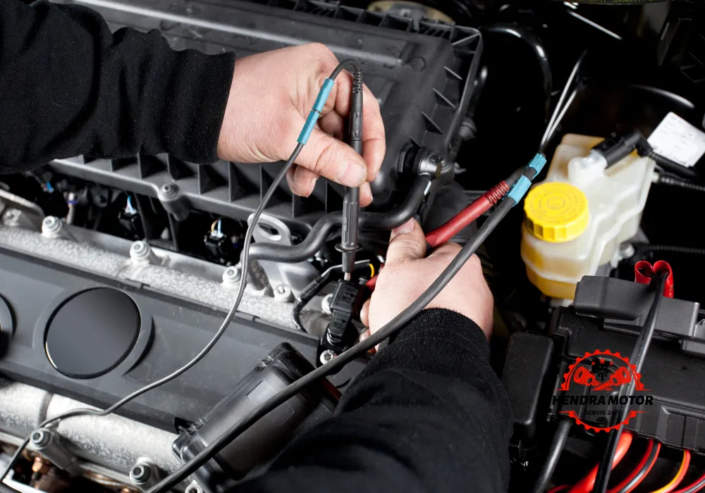 Montir panggilan sedang melakukan pengecekan kelistrikan mobil.