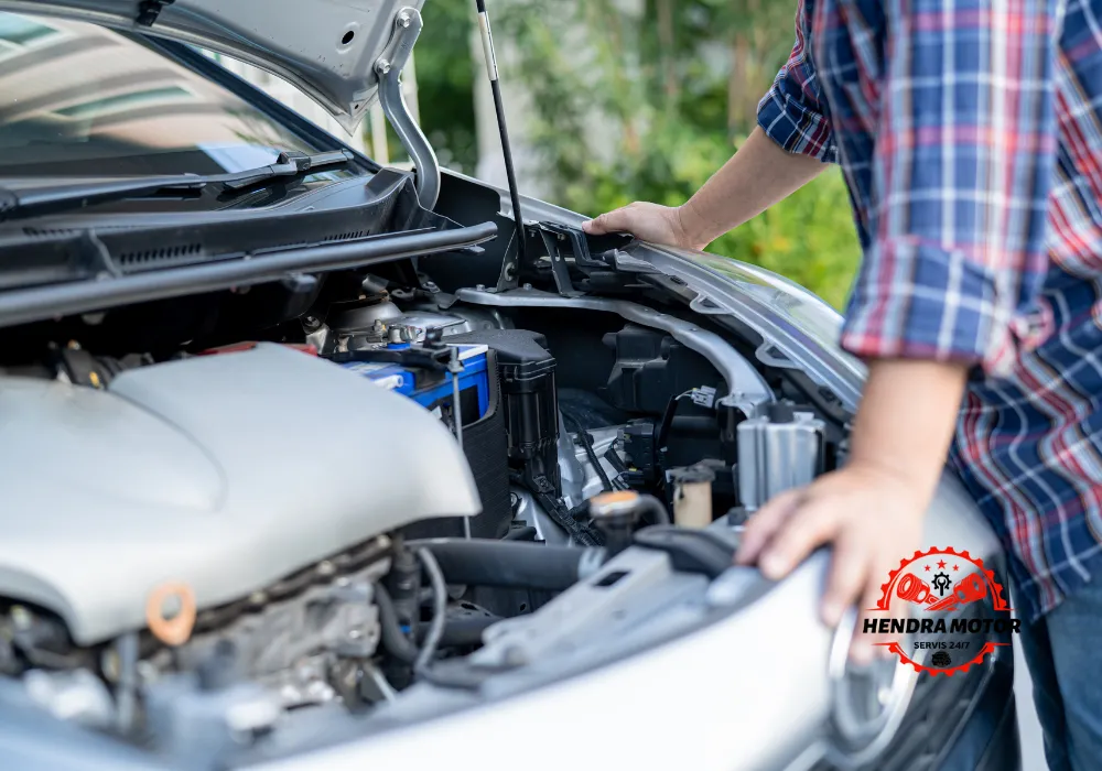 Montir panggilan sedang memperbaiki mobil mogok.