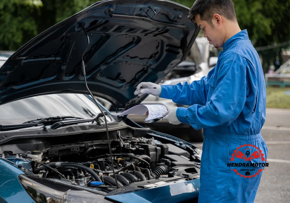 Teknisi sedang memperbaiki mobil mogok di jalan. Service mobil panggilan Bandung