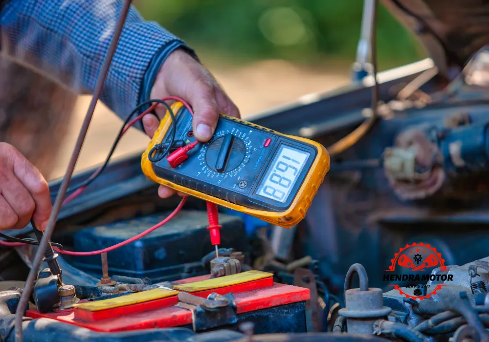 Montir panggilan sedang menangani sistem kelistrikan kendaraan.