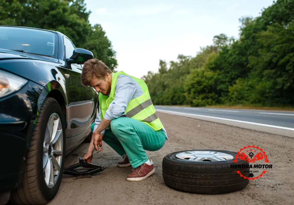 Montir panggilan sedang mengganti ban kendaraan.