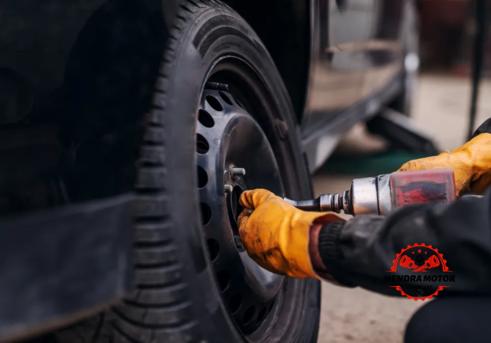 Montir panggilan sedang mengganti ban mobil.