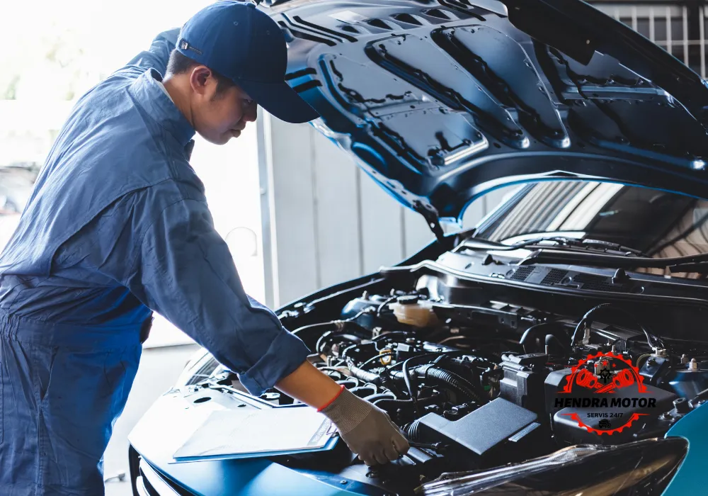 Teknisi sedang melakukan pengecekan kelistrikan mobil. Service mobil panggilan Bandung