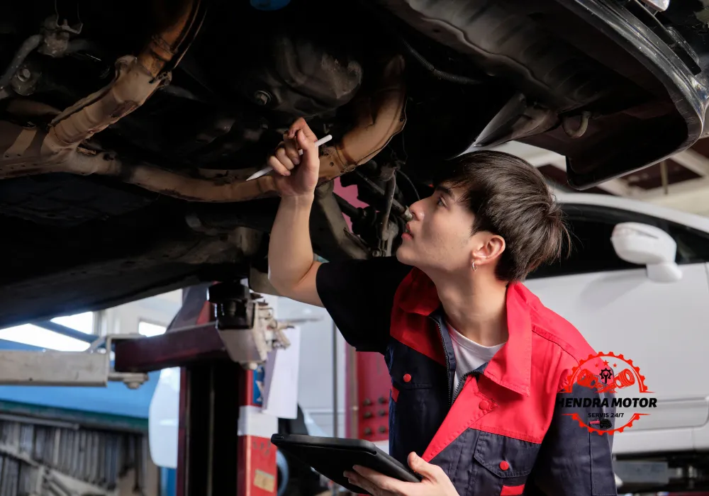 Teknisi bengkel panggilan melakukan tune up mobil.